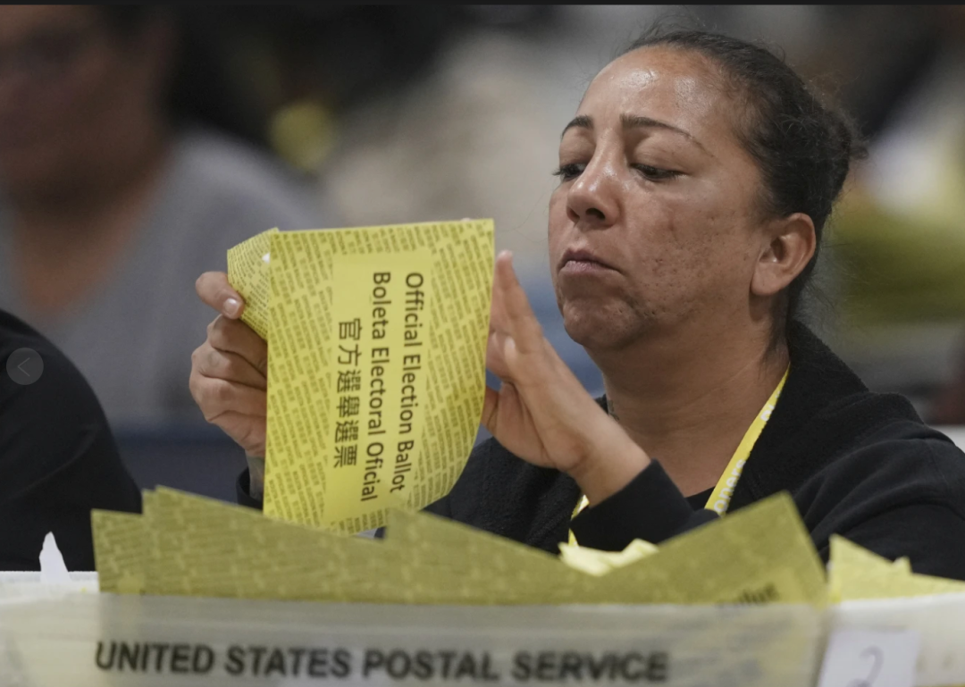 选举当日,一名工作人员在费城的选票仓处理邮寄的选票。